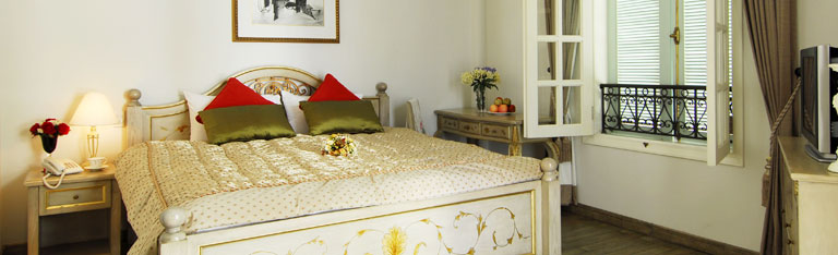 Standard room is uniquely decorated in an elegant fashion style, equipped with a single bed, satellite LCD tivi, ADSL, wooden wardrobe with flowery design on the surface, tiny bathroom through a white wooden sliding door and particular private windy window. The room color is yellow matching perfectly with its warmth and room size. Specific character may count that window doors can open into the room itself bringing romantic sense and even outside from height to the street taking the air and just a little bit sunshine enough for your quick nap. Black pattern brick, white coffee curtains, wriggling design on window railing and curtain hanger produce in harmony with Bordeaux bed runner, flowery cushion-cloth and a cubism painting up above.